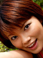 Japanese whore shows off her fine big tits by the rocks